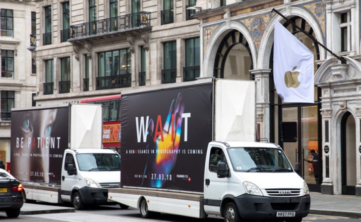 Fotografía de los camiones publicitarios del Huawei P20 frente a una tienda de Apple en Londres.